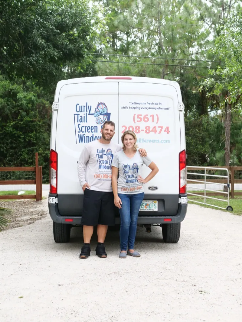 Sean and Kristen, owners of Curly Tail Screen & Window, standing in front of their company van